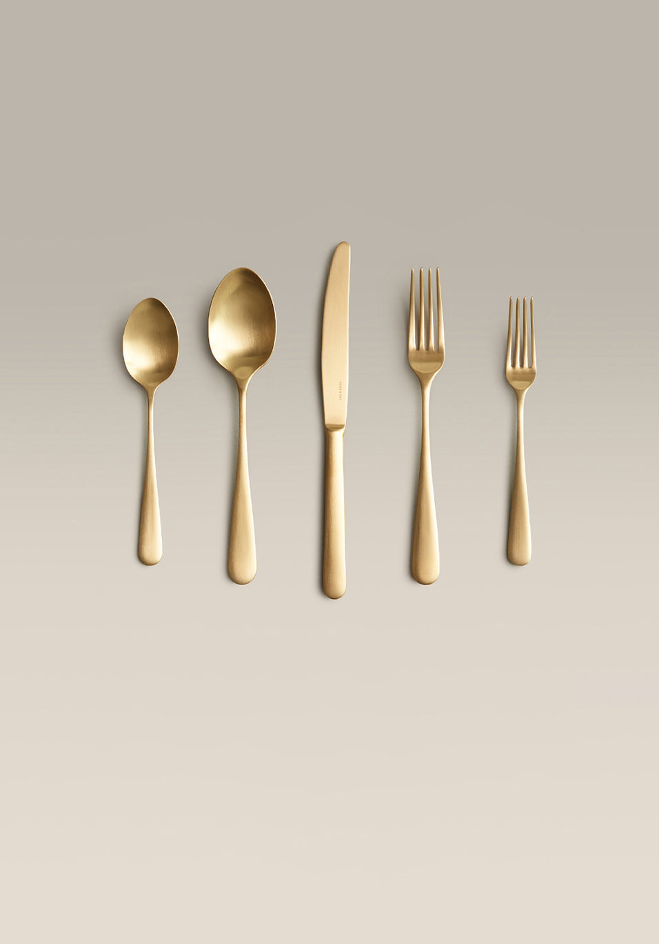 Classic Five-Piece Place Setting, gold, single piece on a plain surface