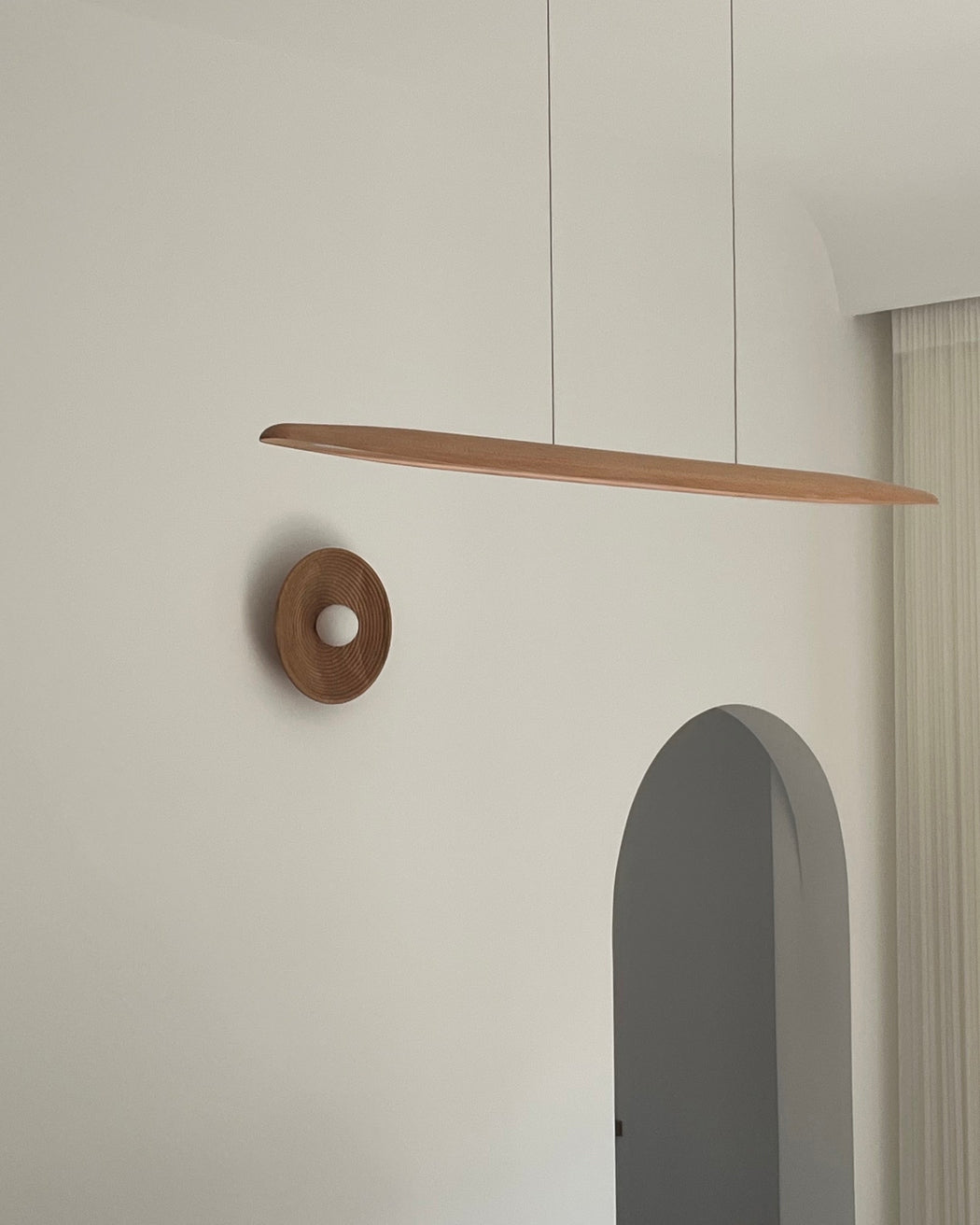 Longleaf Natural Wooden Plate Wall Light, scale beside a doorway