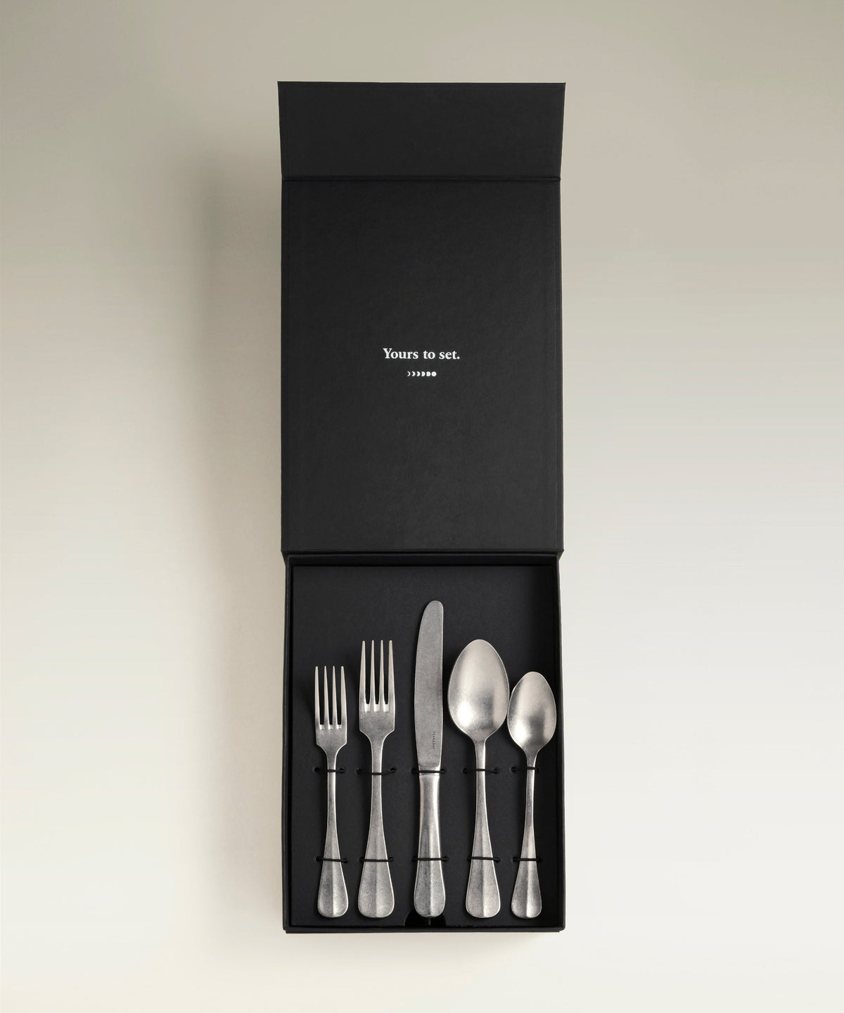 Sea Cliff Four-Person Flatware Set, held in hand for scale