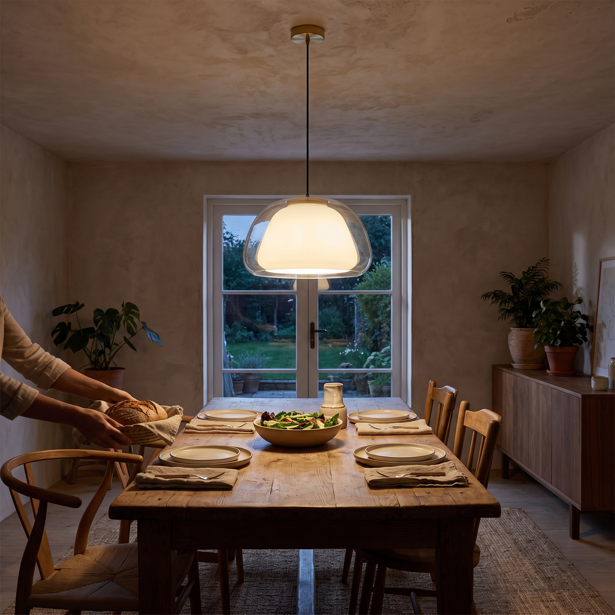 Zabda Metal Pendant Light, lit and hanging in a styled room