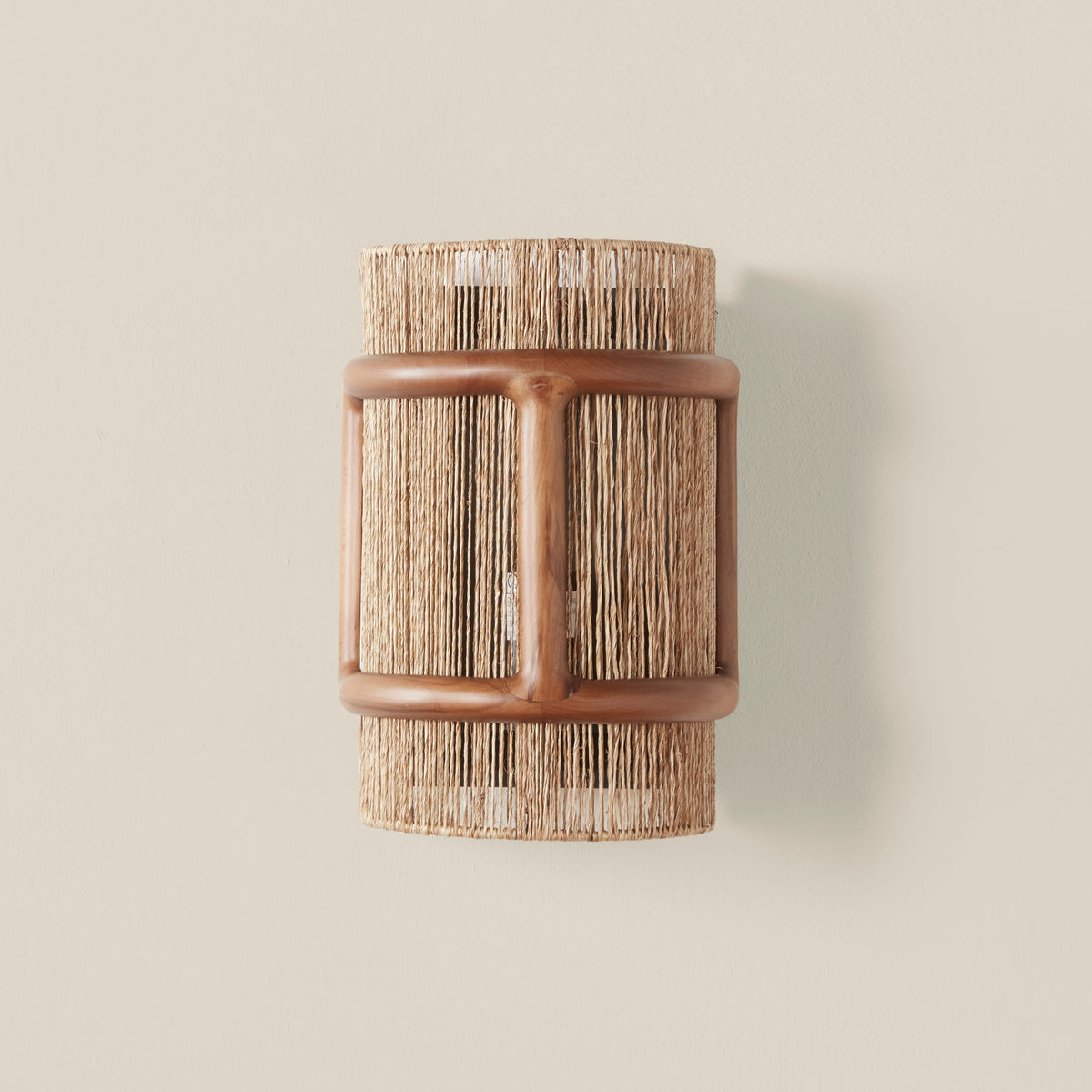 Cala Jute Wall Sconce, lit in a styled room
