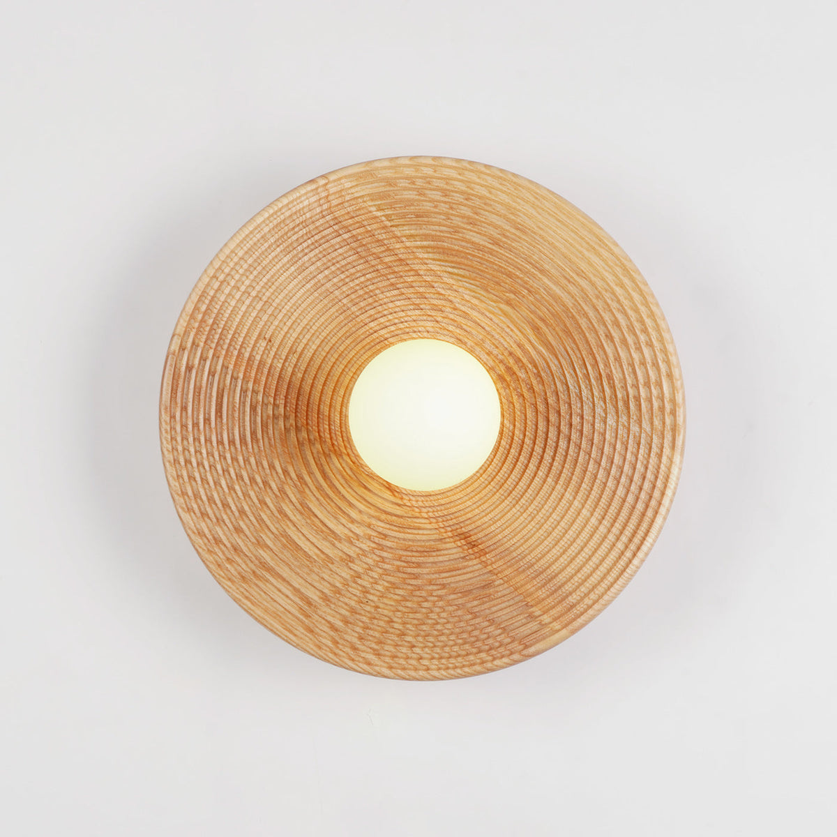 Longleaf Natural Wooden Plate Wall Light, lit after dark