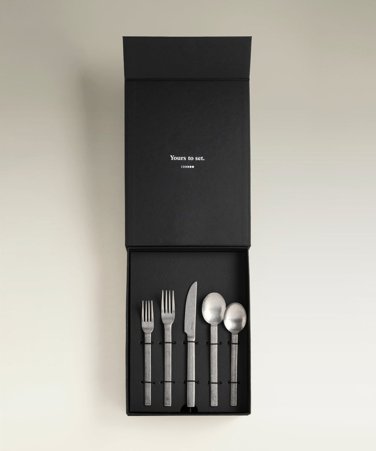 Tomales Four-Person Flatware Set, held in hand for scale
